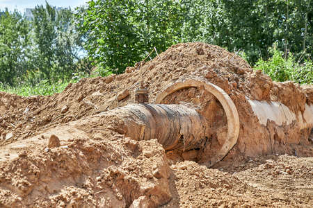 Reconstruction of the water supply network. An old water pipe in a reinforced concrete sleeve was dug out of the groundの写真素材
