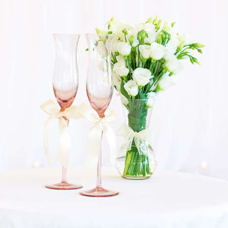 Vase of flowers and wedding glasses on the tableの写真素材