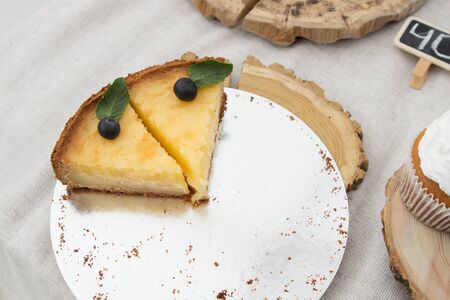 two slices of cheesecake with blueberries and mint on a table