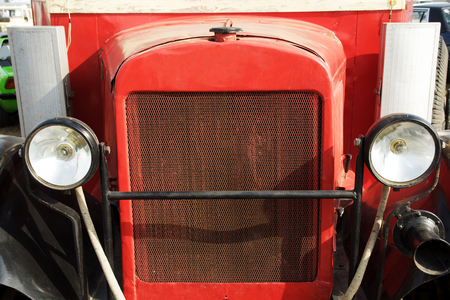 Red vintage car on a festival of old cars. Retro car's headlight close up.の写真素材