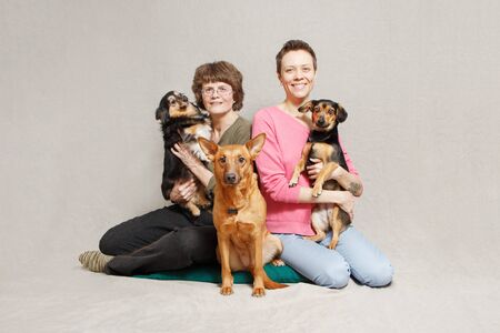 mother and daughter in pink sweater with three dogs in studio