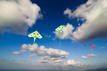 Flying colourful kites in blue skyの写真素材