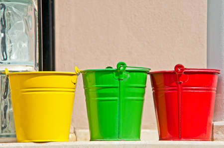 Three buckles in yellow green and red colors on the garden wallの写真素材