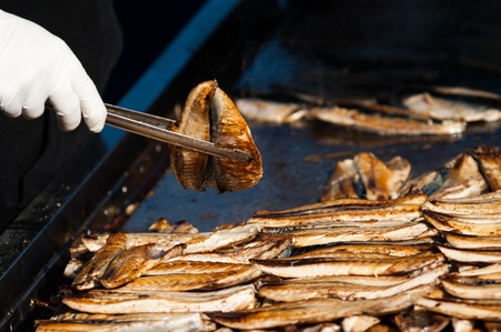 fillet bonito fish palamut on the barbeque with cooker tongs