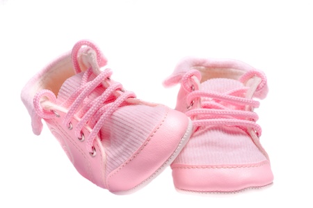 Isolated small pink velvety baby shoes on white