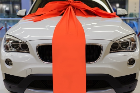 Brand new white present car with large red ribbon decorationのeditorial素材