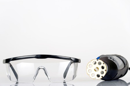 small rotary tool with saw attachment and safety spectacles, isolatedの写真素材