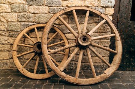 rustic wagon wheels in front of the wall in old city Baku, Azerbaijanの写真素材