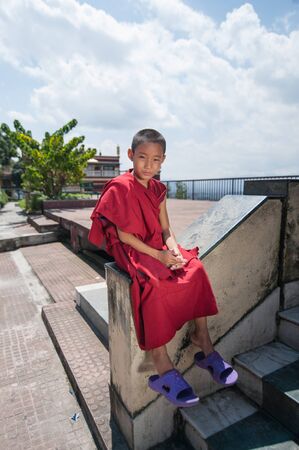 KATHMANDU, NEPAL - AUGUST 27, 2013: Buddhist teenage student portrait in the garden of Kopan...