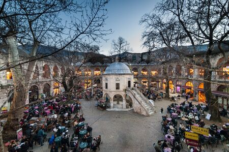 Bursa Turkey  January 24 2015: Tea garden and silk shops in Koza Han Silk Bazaar. Koza Han is very old built in 1451. There are little shops that sell silk clothes shawls and clothのeditorial素材