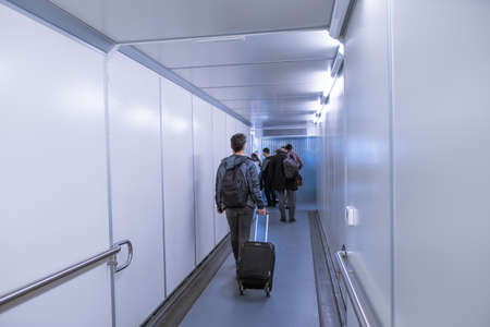 Arnavutkoy, Istanbul, Turkey - 03.08.2021: some passengers with bags and luggage walking to board the airplane in Istanbul Airportのeditorial素材