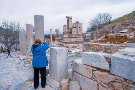 Selcuk, Izmir, Turkey - 03.09.2021: old woman taking photo of remnants in Ephesus ruins, historical ancient Roman archaeological sites in eastern Mediterranean Ionia regionのeditorial素材
