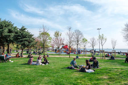 Kadikoy, Istanbul, Turkey - 04.29.2021: Moda Public Park before quarantine day and a lot of people sitting and resting on green grass in a clear Spring day with copy spaceのeditorial素材