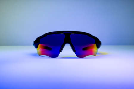 Sport SunGlasses with colourful glasses and black frame on blue backgroundの写真素材