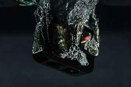 Creative Underwater photo of action camera, drowning in the water. Black backgroundの写真素材