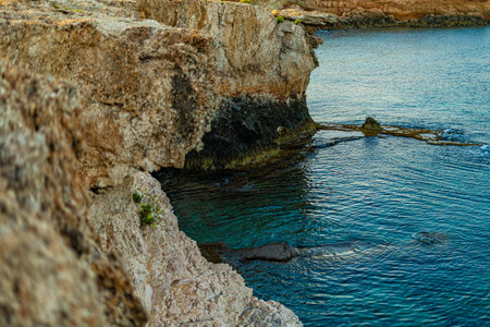 Photo of rocky coastline with blue water and waves in Mediterranean sea in Cyprusの写真素材