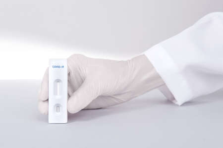 Doctor or scientist hand with white glove holding a test kit for viral disease COVID-19 2019-nCoV or Lab card kit test for coronavirus SARS-CoV-2 virusの写真素材