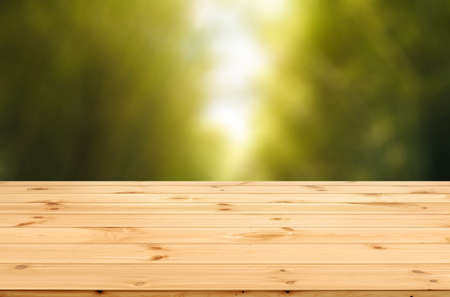 Wood desk and empty space for adverstisement display with blured bamboo forest against with sunlight