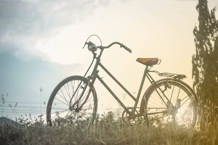 Landscape picture Vintage Bicycle with Summer grass field at sunset. color of vintage tone and soft...