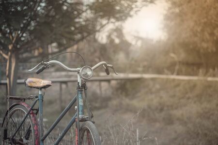 Landscape picture Vintage Bicycle with Summer grass field at sunset. color of vintage tone and soft focus concept journey.close upの写真素材