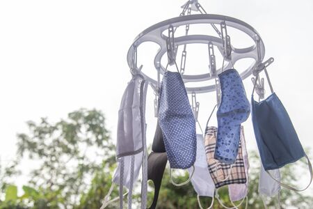 Cotton cloth mask hanging outdoor after the used and washing,natural glare light, times,after use every day should wash and dry in the sun to be sterilized as well,coronavirusの写真素材