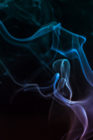 colorful smoke on dark backgroundの写真素材