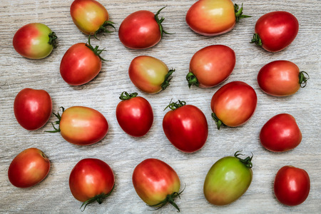 Tomatoes on the wooden table background, top viewの写真素材