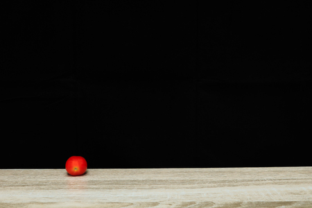 tomato on black background and wooden backgroundの写真素材