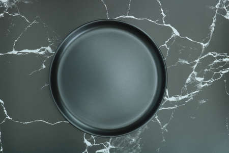 Black empty plate on marble, flat lay, food menu concept, stone table on top viewの写真素材