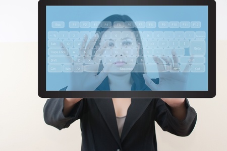 Business lady pressing transparent keyboard on the tablet screen.の写真素材