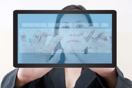 Business lady pressing transparent keyboard on the tablet screen.
