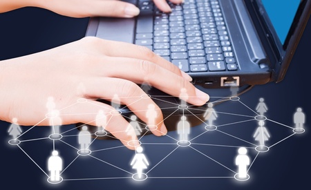 Hand pushing laptop keyboard with social network.