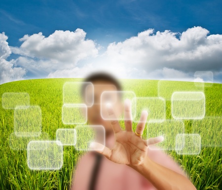 Asian businessman pushing button on the blue sky field.の写真素材