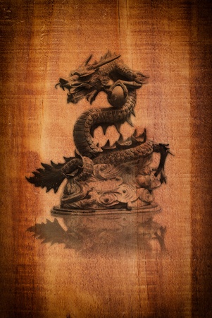 Dragon statue on the wood texture.の写真素材