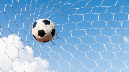 Soccer football in Goal net with sky field の写真素材