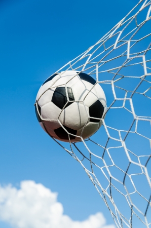 Soccer football in Goal net with sky field の写真素材