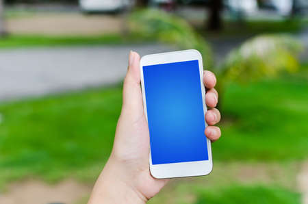 Hand Holding Mobile Phone in the nature 