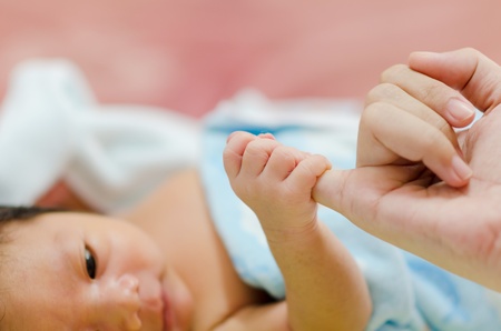 Baby Hand Holding Mother Fingerの写真素材