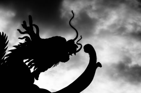 Chinese style Dragon statue silhouette with sunset.の写真素材