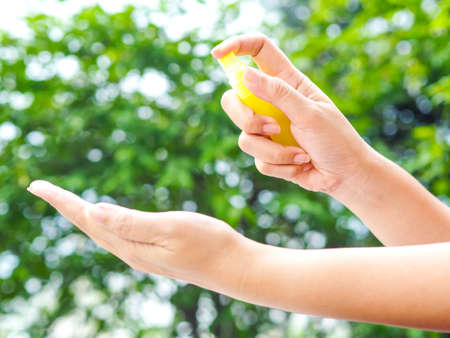 Womanâs hand pressing Alcohol Spray in the nature for clean her hand. Alcohol Spray is very important in daily life.の写真素材