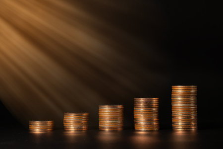 Stack of coins on a black background the sun shines softly