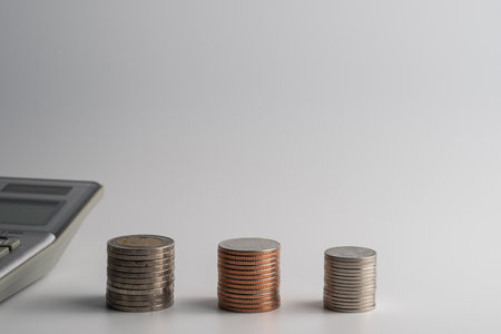 Business, finance, money and bookkeeping concept - calculator and Thailand coins on office tableの写真素材