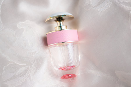 Pink perfume bottle on white fabric background with copy space for text.の写真素材