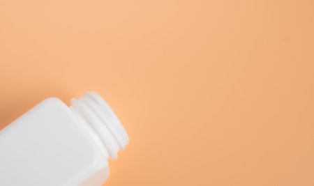 white plastic bottle on orange background with copy space for text or image