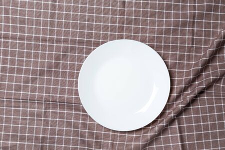 A wooden vintage Table or background with a dish towel and plate, top viewの写真素材