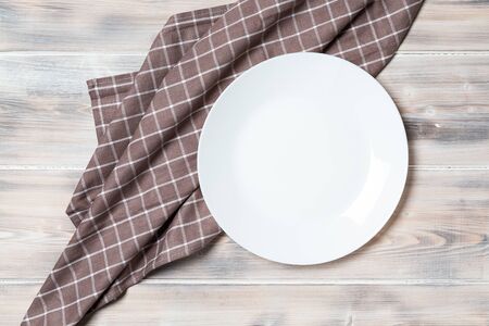 A wooden vintage Table or background with a dish towel and plate, top viewの写真素材