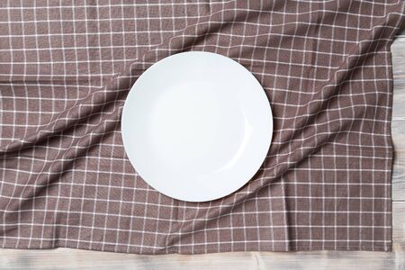 A wooden vintage Table or background with a dish towel and plateの写真素材