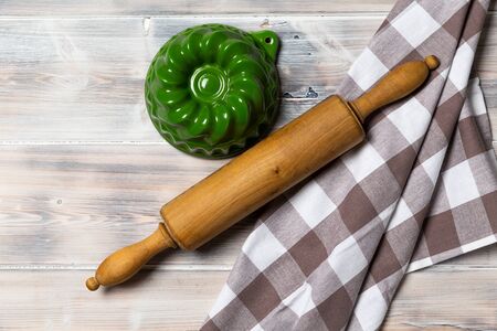 A wooden vintage Table or background with a dish towel and pastry rollerの写真素材