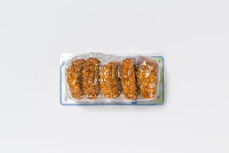Use less plastic! Food in plastic packaging isolated on white ground. Symbol for environmental...