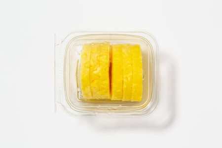 Use less plastic! Ananas in plastic packaging isolated on white ground. Symbol for environmental pollution done by the food industryの写真素材